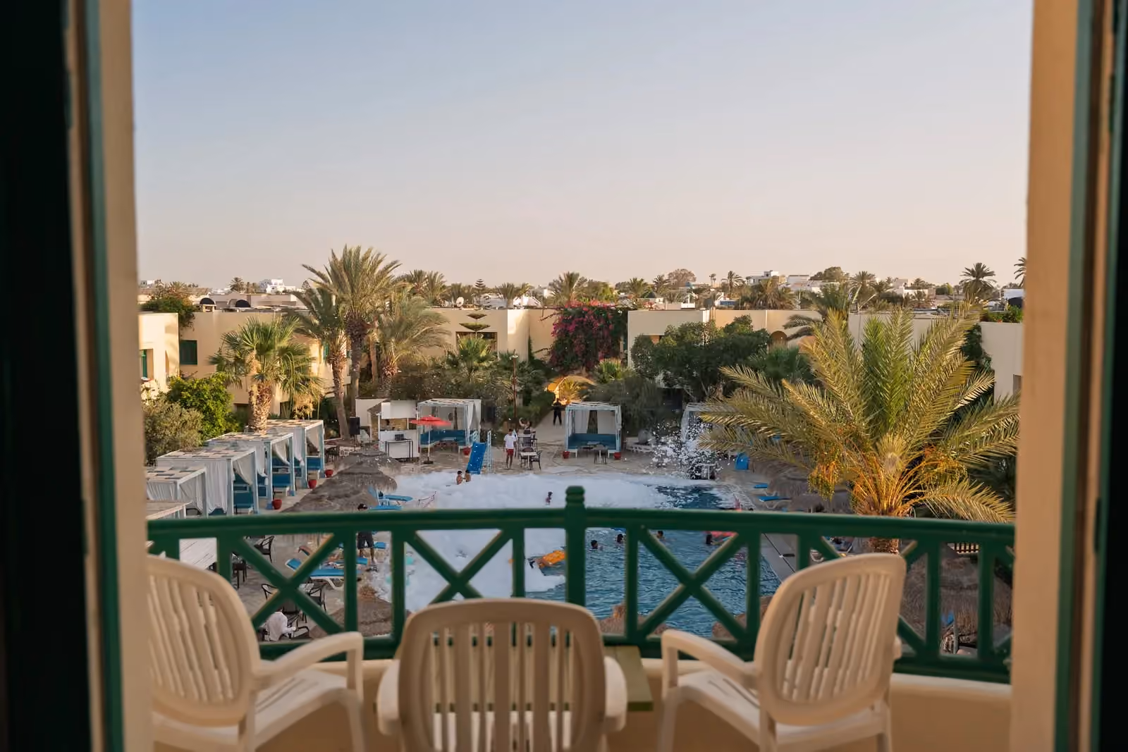 La piscine et les jardins de l’hôtel, vus depuis un balcon au soir