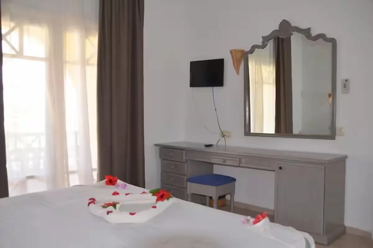Coin bureau d’un appartement famille : commode, miroir et télévision