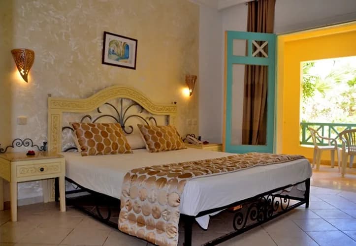 Chambre vue piscine : lit double, décoration sobre, porte-fenêtre sur le balcon